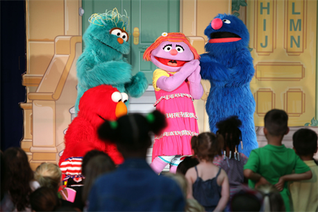 Elmo and his friends console Katie, a new member to the Sesame Street cast, during a USO performance of Sesame Street Live aboard Marine Corps Air Station New River, April 28. Katie, a military child, was distraught over moving to a new town before the Sesame Street cast showed her and the audience how she can cope with her new life. 