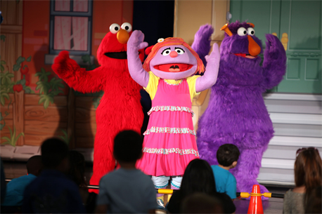 Elmo and his friends console Katie, a new member to the Sesame Street cast, during a USO performance of Sesame Street Live aboard Marine Corps Air Station New River, April 28. Katie, a military child, was distraught over moving to a new town before the Sesame Street cast showed her and the audience how she can cope with her new life.